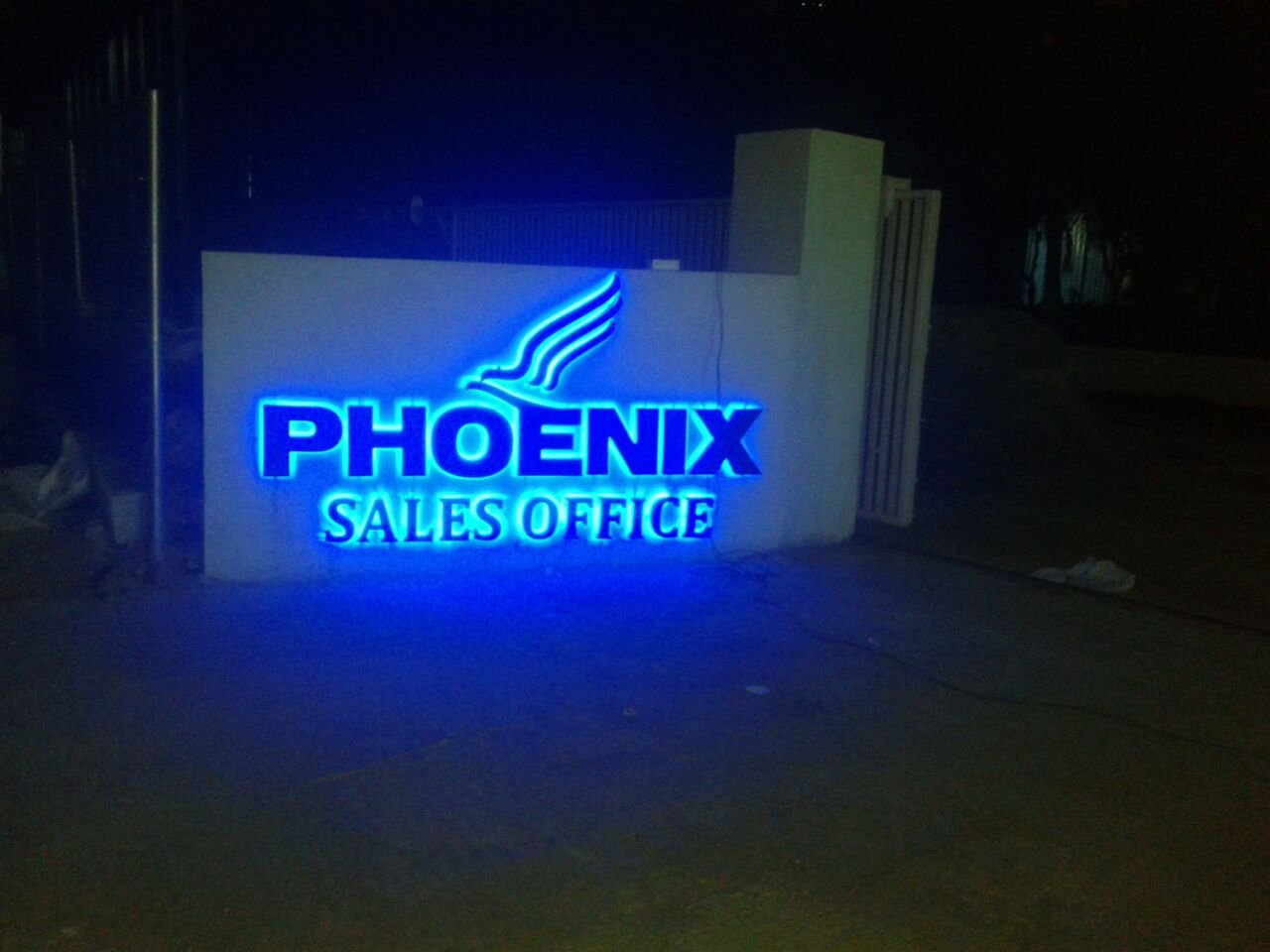 Backlit blue logo signage at night